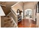 Bright hallway featuring hardwood floors, a staircase, and an open layout leading to the living areas at 8909 Savannah Rd, Harrisburg, NC 28075