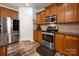 Kitchen features wood cabinets, stainless steel appliances, granite countertops, and modern flooring at 8909 Savannah Rd, Harrisburg, NC 28075