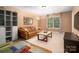 A comfortable living room featuring a leather sofa, carpet, and a large window at 8909 Savannah Rd, Harrisburg, NC 28075