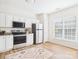 Bright kitchen features white cabinets, stainless steel appliances, and a large window at 9030 Gander Dr, Charlotte, NC 28277