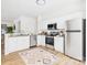 Bright kitchen with white cabinets, stainless steel appliances, granite countertops, and laminate flooring at 9030 Gander Dr, Charlotte, NC 28277