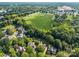 Aerial view showcasing the neighborhood's lush greenery and proximity to a large green sports field at 9038 Sandpiper Dr, Charlotte, NC 28277
