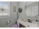 Cozy powder room with a window for natural light, decorative mirror, and dark faucet at 9038 Sandpiper Dr, Charlotte, NC 28277