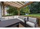 Comfortable outdoor deck with shaded pergola, plush seating and wooded backyard views at 9038 Sandpiper Dr, Charlotte, NC 28277