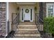 Inviting front entrance with stone steps, black iron railings, and a decorative wreath on the white door at 9038 Sandpiper Dr, Charlotte, NC 28277