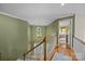 Upstairs hallway featuring hardwood floors, a chandelier, and a view of the bedroom at 9038 Sandpiper Dr, Charlotte, NC 28277