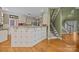 Well-lit kitchen with tiled breakfast bar, hardwood floors, and adjacent staircase at 9038 Sandpiper Dr, Charlotte, NC 28277