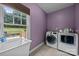 Convenient laundry room with a deep sink, washer, dryer, and a window with a view of the backyard at 9038 Sandpiper Dr, Charlotte, NC 28277
