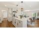 Bright kitchen features white cabinets, stainless appliances, island with breakfast bar, and open floor plan at 922 Maurice St, Monroe, NC 28112