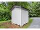 Exterior view of a small white shed on the property, surrounded by lush greenery at 922 Maurice St, Monroe, NC 28112