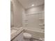 Bright bathroom featuring a tub with shower, granite countertop, and sleek white fixtures at 1017 W C St, Kannapolis, NC 28081