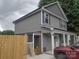 Two-story home featuring gray siding, complemented by white trim and a cozy side patio with wood privacy fence at 1017 W C St, Kannapolis, NC 28081