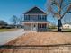Inviting two-story home featuring a fresh gray exterior, manicured lawn, and a convenient concrete driveway at 1017 W C St, Kannapolis, NC 28081