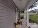 Charming front porch with gray siding, white pillars, and a view of the lawn and neighboring church at 1017 W C St, Kannapolis, NC 28081