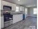 A modern kitchen with stainless steel appliances, white cabinets, and granite countertops offers a clean design at 1017 W C St, Kannapolis, NC 28081