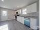 A modern kitchen with stainless steel appliances, white cabinets, and granite countertops offers a clean design at 1017 W C St, Kannapolis, NC 28081