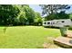 Expansive backyard highlighting a trailer, trampoline, and lush green grass under a sunny sky at 1020 N Ransom St, Gastonia, NC 28052