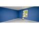 Bright bedroom features marble floors, vibrant blue walls, and a well-lit window with view of yard at 1020 N Ransom St, Gastonia, NC 28052