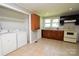Functional kitchen with washer/dryer hookups, tile flooring, and ample cabinet space at 1020 N Ransom St, Gastonia, NC 28052