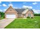 Charming brick home with an attached garage and a well-manicured lawn, perfect for suburban living at 116 Postell Dr, Statesville, NC 28625