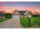 Lovely brick home with an attached garage, surrounded by a lush green lawn at dusk at 116 Postell Dr, Statesville, NC 28625