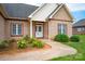 Inviting front entrance with a brick facade, white trim, and well-maintained landscaping at 116 Postell Dr, Statesville, NC 28625
