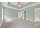 Large main bedroom showing tray ceiling, two doors, neutral paint, and carpet at 116 Postell Dr, Statesville, NC 28625