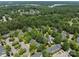 Community aerial view showcases mature trees, housing, and a serene lake in the distance at 12516 Hennigan Place Ln, Charlotte, NC 28214