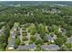 Aerial view of townhomes in a wooded community near a lake, promoting a serene lifestyle at 12516 Hennigan Place Ln, Charlotte, NC 28214