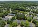 Aerial view of a serene community showcasing a pond, lush trees, and well-maintained townhomes at 12516 Hennigan Place Ln, Charlotte, NC 28214