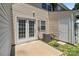 Back patio showcasing french doors, AC unit, window, and a cozy outdoor space at 12516 Hennigan Place Ln, Charlotte, NC 28214