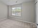 Bright bedroom featuring neutral tones, a window letting in natural light, and carpet at 12516 Hennigan Place Ln, Charlotte, NC 28214