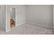 Bedroom featuring neutral tones, a window, and door to the bathroom at 12516 Hennigan Place Ln, Charlotte, NC 28214