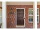 A close-up of the brick front entrance showing the house number and a dark wooden door at 12516 Hennigan Place Ln, Charlotte, NC 28214