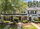 Well-maintained townhome featuring a charming brick facade, lush landscaping, and inviting entrance at 12516 Hennigan Place Ln, Charlotte, NC 28214