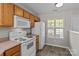 Kitchen features wood cabinets, white appliances, and a window for natural light at 12516 Hennigan Place Ln, Charlotte, NC 28214