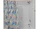Shower with white tile and a colorful shower curtain at 12516 Hennigan Place Ln, Charlotte, NC 28214
