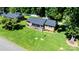 Aerial view of brick home with a well-manicured lawn and mature trees at 135 Burton Hills Cir, Gastonia, NC 28054