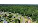 An aerial shot showcases the residential area featuring neat lawns, tree-lined streets, and nearby wooded scenery at 135 Burton Hills Cir, Gastonia, NC 28054