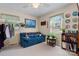 Bright bedroom with a blue sofa, bookcase, and natural light from the windows at 135 Burton Hills Cir, Gastonia, NC 28054
