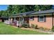 Charming brick home with a cozy front porch, manicured lawn, and colorful flower beds at 135 Burton Hills Cir, Gastonia, NC 28054