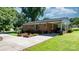 Charming brick home with a well-manicured lawn and mature trees, carport, and long driveway at 135 Burton Hills Cir, Gastonia, NC 28054