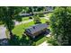 Aerial shot of a brick home with a well-maintained lawn and a small patio in a verdant neighborhood at 135 Burton Hills Cir, Gastonia, NC 28054