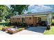 Charming brick home with a well-manicured lawn, mature trees, carport, brick flower beds, and long driveway at 135 Burton Hills Cir, Gastonia, NC 28054