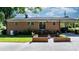 Charming brick home with a well-manicured lawn, mature trees, brick flower beds, and long driveway at 135 Burton Hills Cir, Gastonia, NC 28054