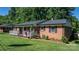 Classic brick home featuring a welcoming front porch and manicured garden at 135 Burton Hills Cir, Gastonia, NC 28054