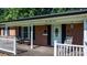 Charming brick home with a welcoming front porch, rocking chair, and colorful flowers at 135 Burton Hills Cir, Gastonia, NC 28054