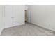 A spare bedroom with neutral carpet, a double closet and an adjacent doorway at 15209 Loire Valley St, Charlotte, NC 28277