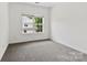 Clean, empty bedroom with a large window offering natural light and a neutral color palette at 15209 Loire Valley St, Charlotte, NC 28277