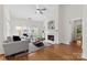 Bright living room with hardwood floors, a ceiling fan, a fireplace, and plush seating, creating a cozy atmosphere at 15209 Loire Valley St, Charlotte, NC 28277
